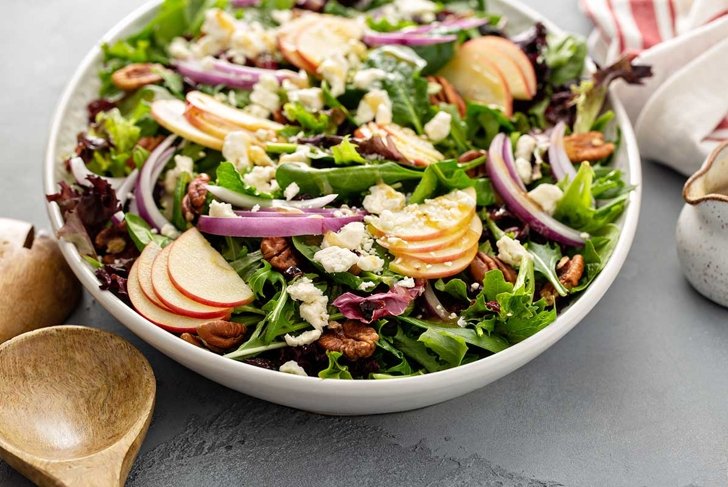 Winter salad with apple, red onion and pecans with vinaigrette dressing