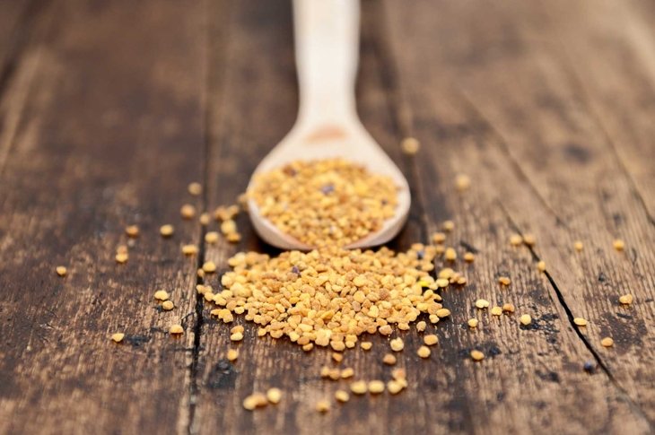spoon with seeds isolated on pollen focus on rustic background