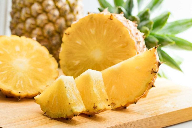 fresh pineapple fruit and pineapple slice on wooden table