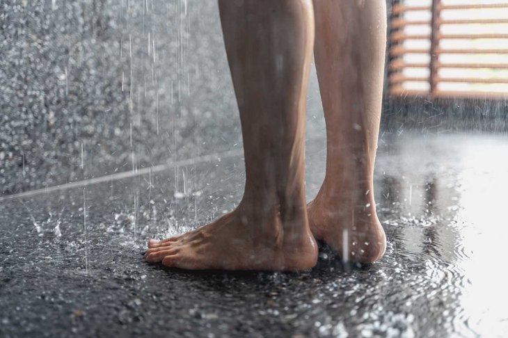 Legs of the girl standing under the shower under the stream of water, health beauty and hygiene concept.