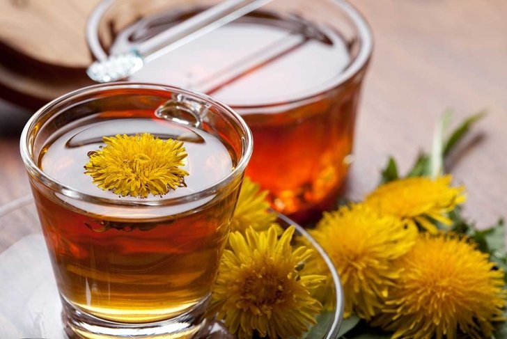 herbal tea infusion of fresh dandelion leaf, with yellow blossoms and honey