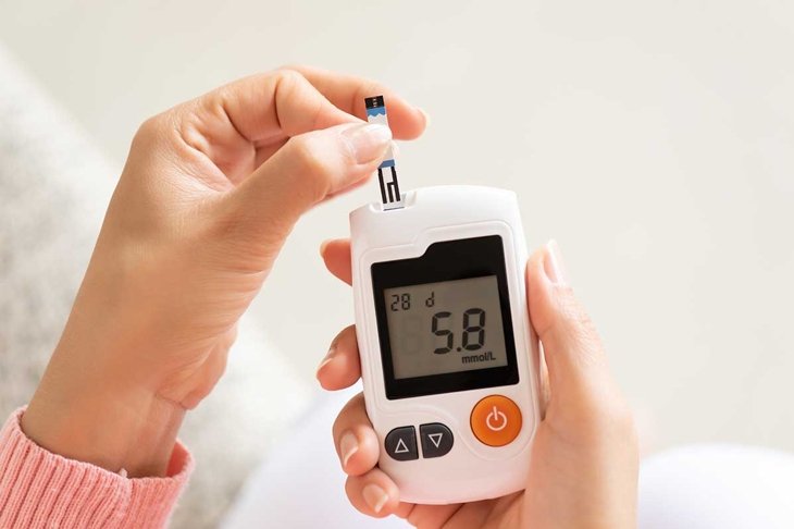 Close up of woman hands checking blood sugar level by Glucose meter for diabetes tester using as Medicine, glycemia, healthcare and medical concept.