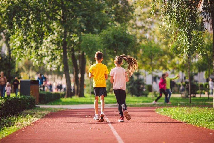 Kids run. Healthy sport. Child sport, heterosexual twins running on track, fitness. Joint training. Running training outdoor brother and sister pre-teen. Jogging with friend. Children athletes.