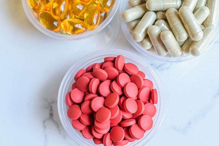 Close up Vitamins and Supplements Background consist of Iron Dietary Supplement, Neem herbal Supplement, Cod Liver Oil Dietary Supplement on a marble background.