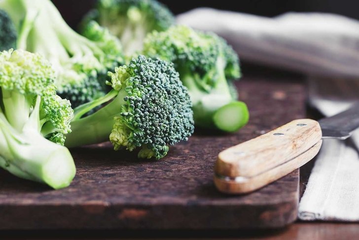 Close-up of a fresh broccoli on a cutting board. The concept of vegetarian and healthy food.