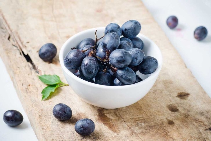 Red grape in a bowl on wooden,Healthy fruit